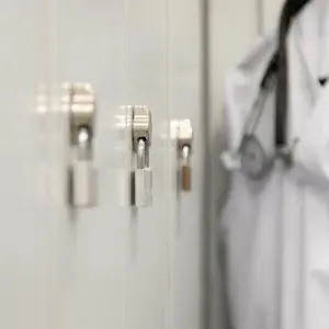 Ein Arztkittel hängt in einem Krankenhaus vor einem Spind