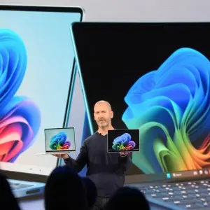 Microsoft-Manager Brett Ostrum zeigt ein Notebook und ein Tablet