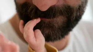 Baby fasst Vater in den Bart