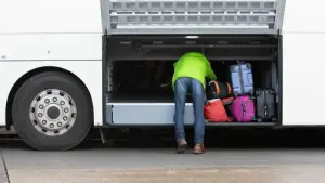 Person an Fernbus-Kofferraum