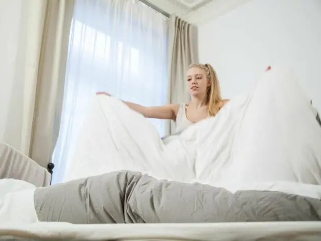 Eine Frau bezieht ein Bett
