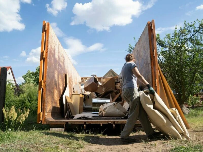 Jemand entsort seinen Sperrmüll in einem Container