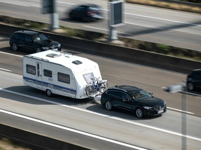 Ein Auto mit einem Wohnwagen fährt auf der Autobahn