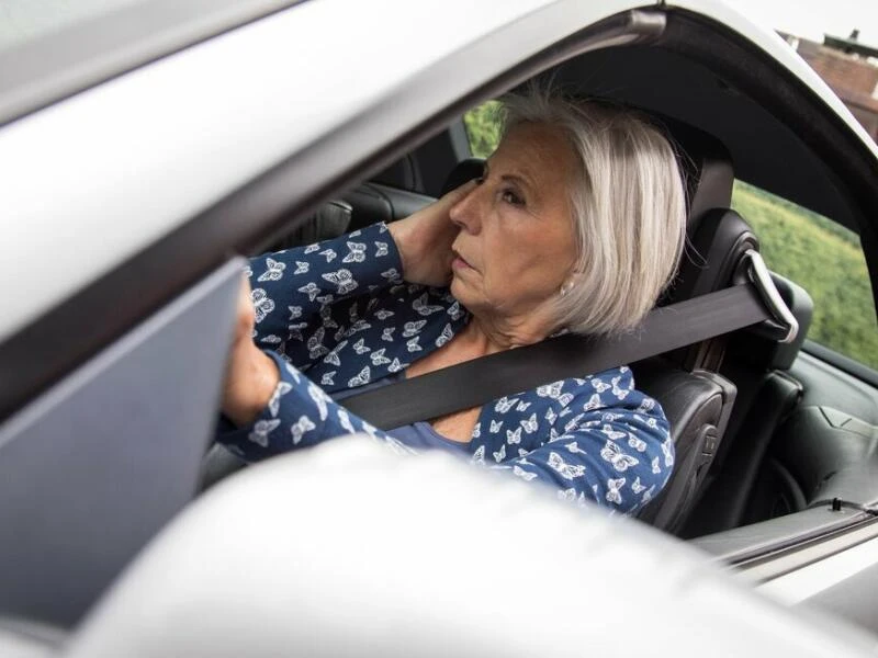 Frau mit tränenden Augen im Auto