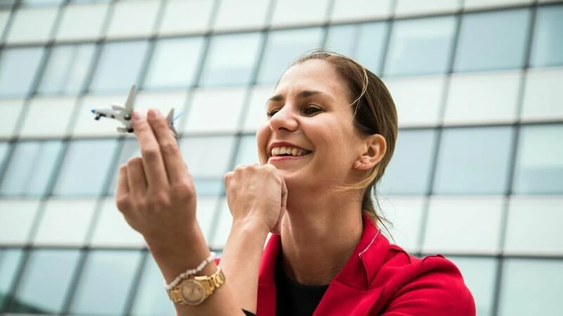 Eine Frau hält ein Modellflugzeug in der Hand