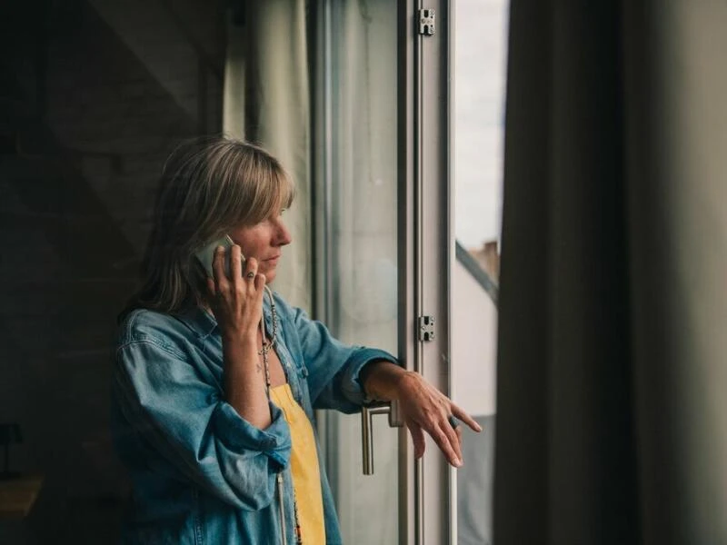 Eine Frau telefoniert am Fenster