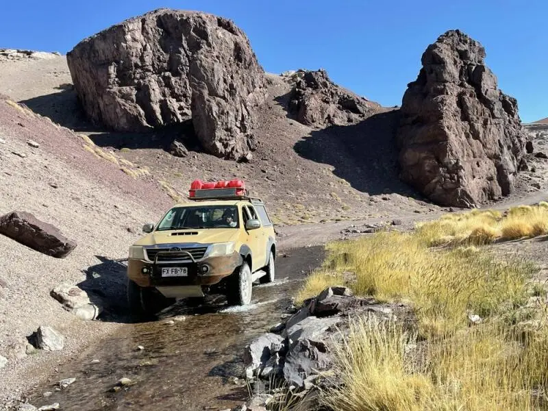 Ein Geländewagen fährt durch einen Bach in der Wüste