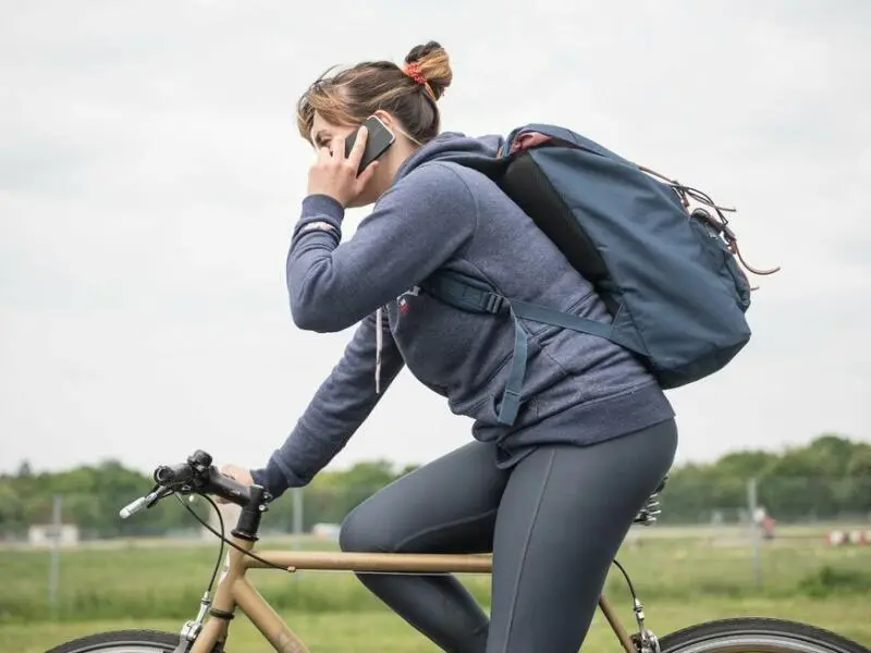 Eine Radfahrerin telefoniert