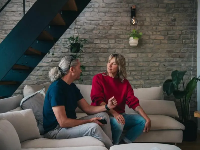 Ein Mann und eine Frau sitzen angespannt auf einem Sofa