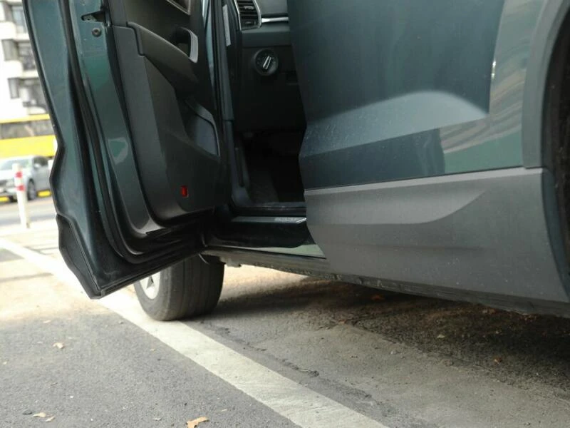 Auto parkt mit offener Autotür am Straßenrand