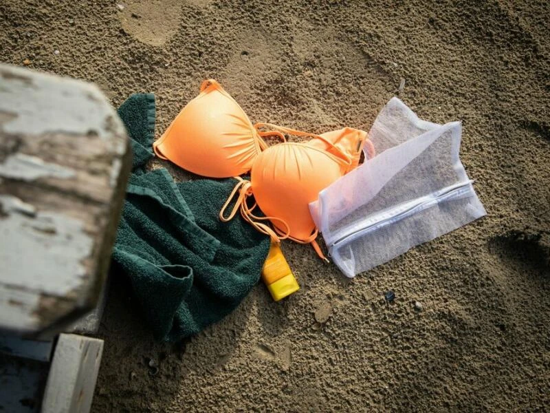 Waschnetz und Badeutensilien liegen im Sand