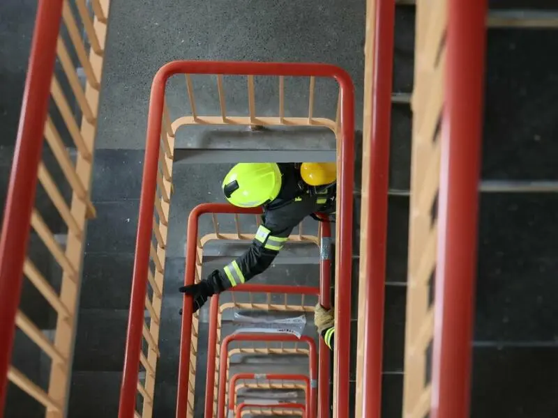 Ein Feuerwehrmann rennt eine Treppe hoch