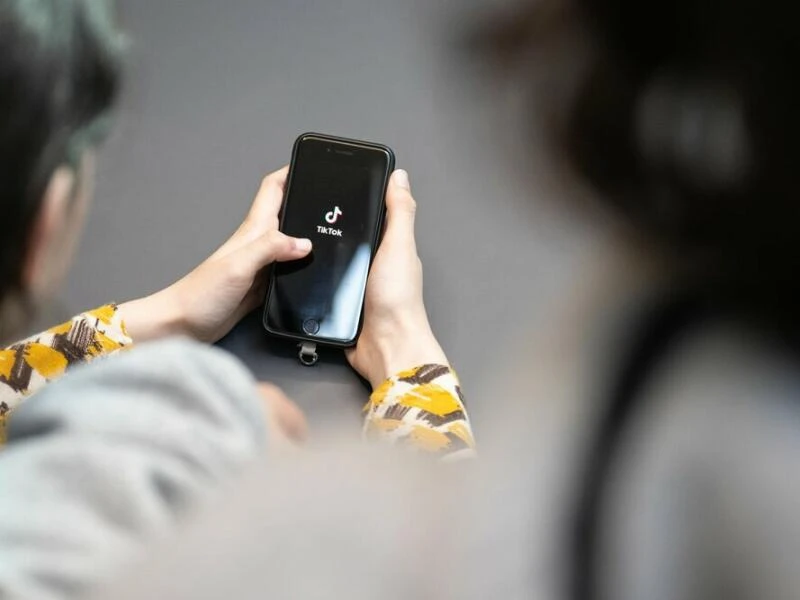 Jugendlicher schaut auf ein Smartphone mit der App von TikTok