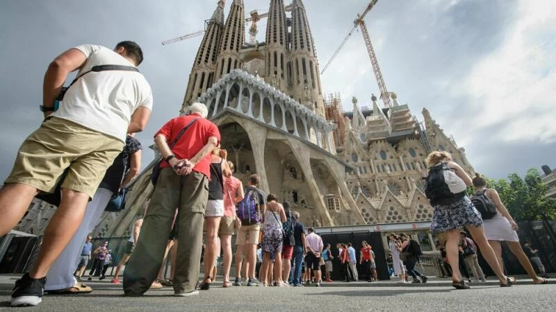 Touristen stehen vor der Basilika La Sagrada Familia