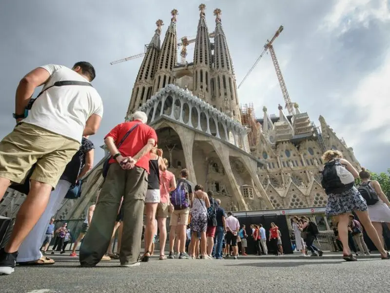 Touristen stehen vor der Basilika La Sagrada Familia