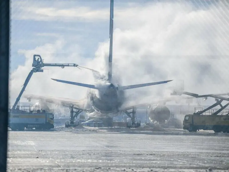 Ein Flugzeug wird am Münchner Flughafen von Eis befreit