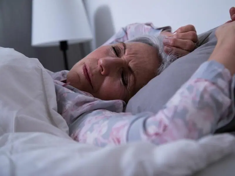 Eine ältere Frau liegt im Bett