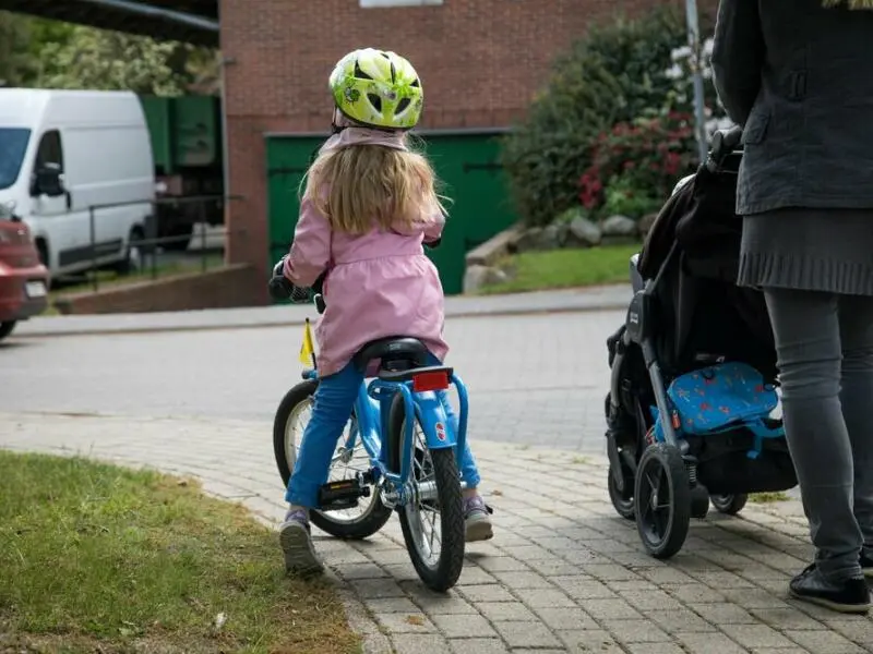 Ein Kind fährt auf dem Gehweg Fahrrad