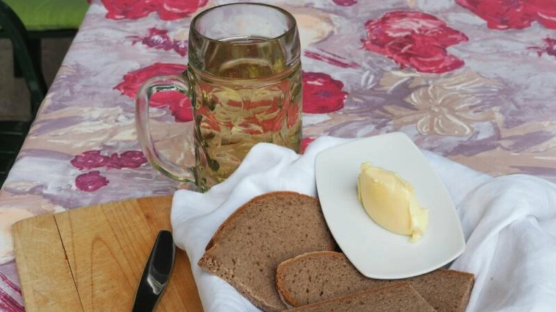 Brot, Butter und Bier stehen auf einem Tisch