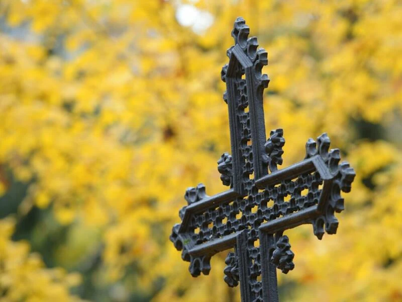 Ein eisernes Kreuz steht auf einem Friedhof