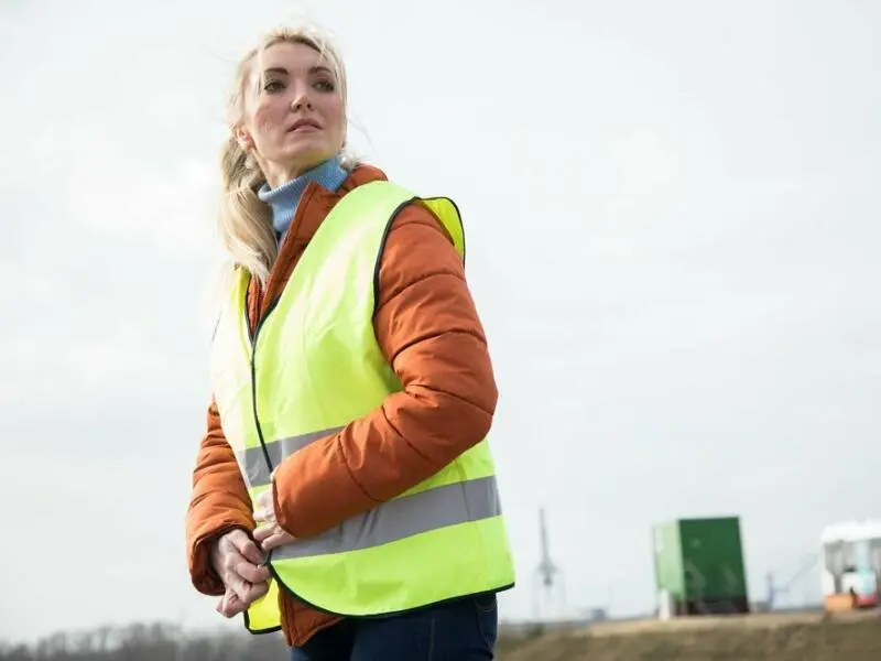 Frau zieht sich eine Warnweste an