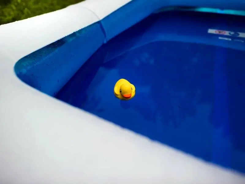 Eine gelbe Plastik-Ente schwimmt in einem Pool