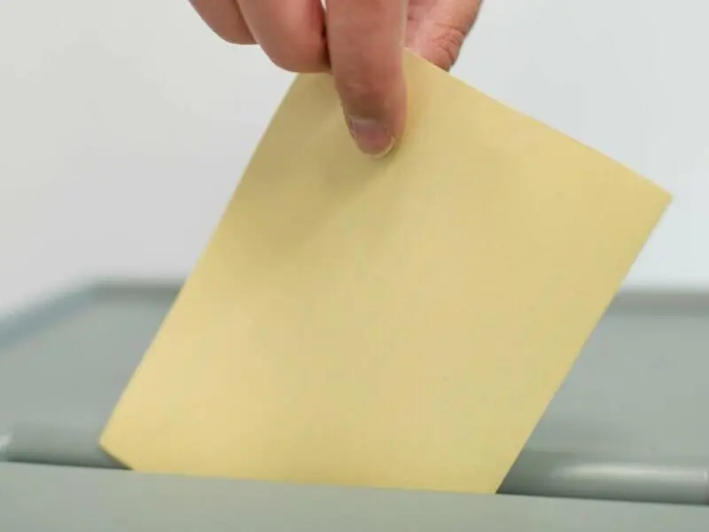 Ein Mann wirft einen Stimmzettel in eine Wahlurne