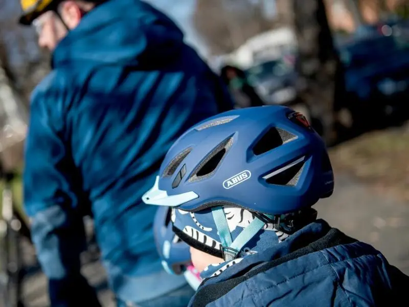 Ein Kind trägt einen blauen Fahrradhelm