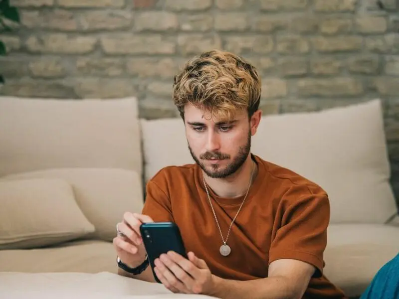 Ein junger Mann bedient sein Smartphone