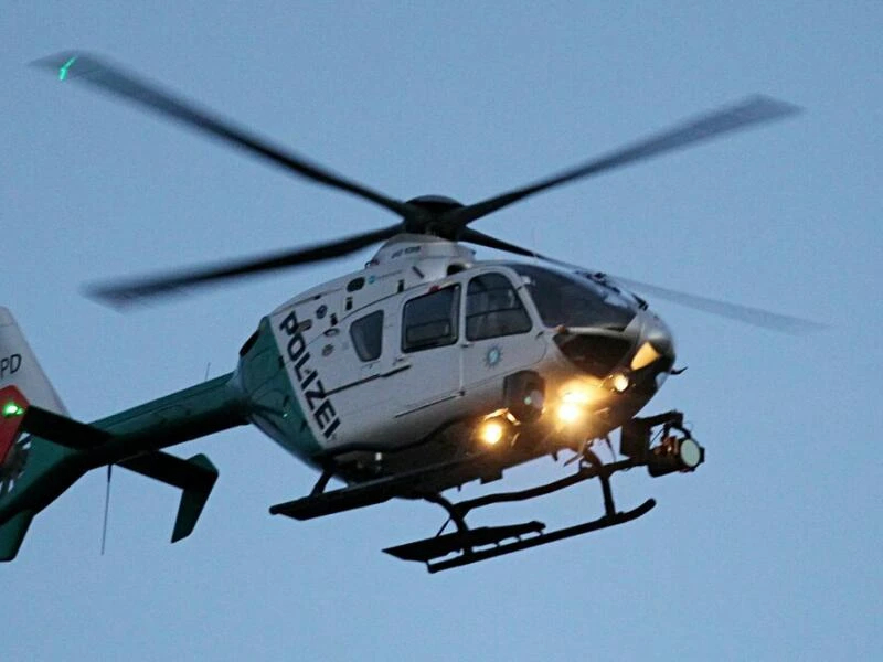 Ein Polizeihubschrauber mit eingeschalteten Scheinwerfern