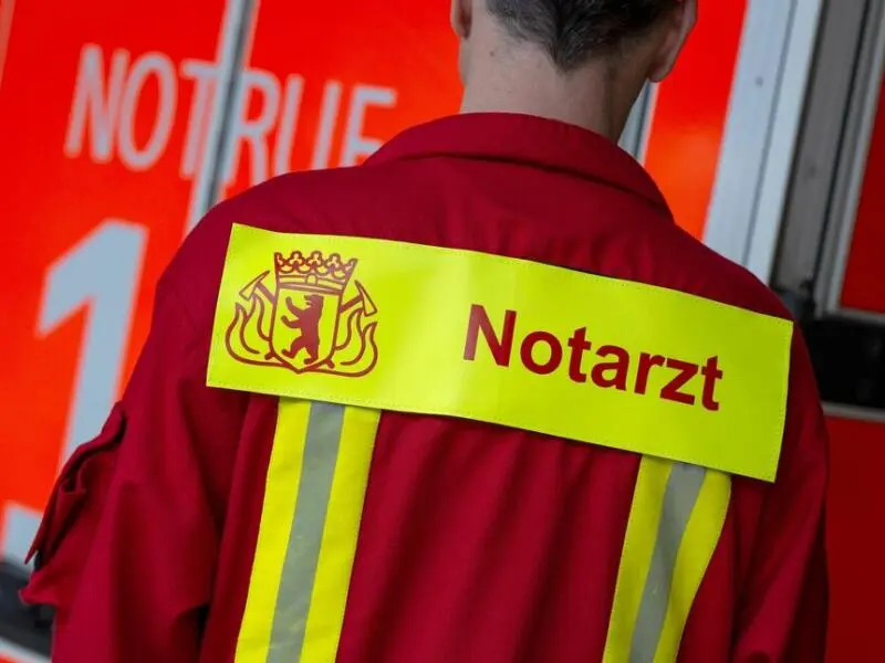 Ein Notarzt steht vor einem Rettungswagen