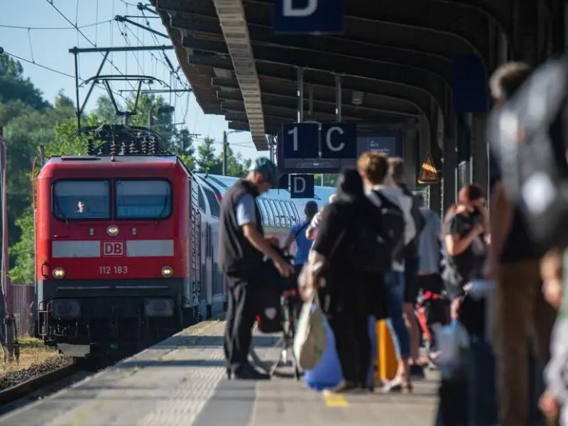 Reisende an einem Bahnhof