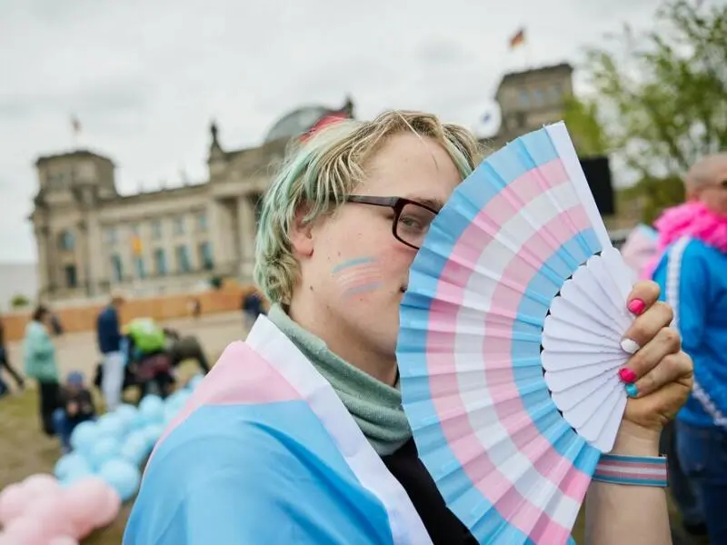 Amity hält einen Fächer in den Transgender-Farben