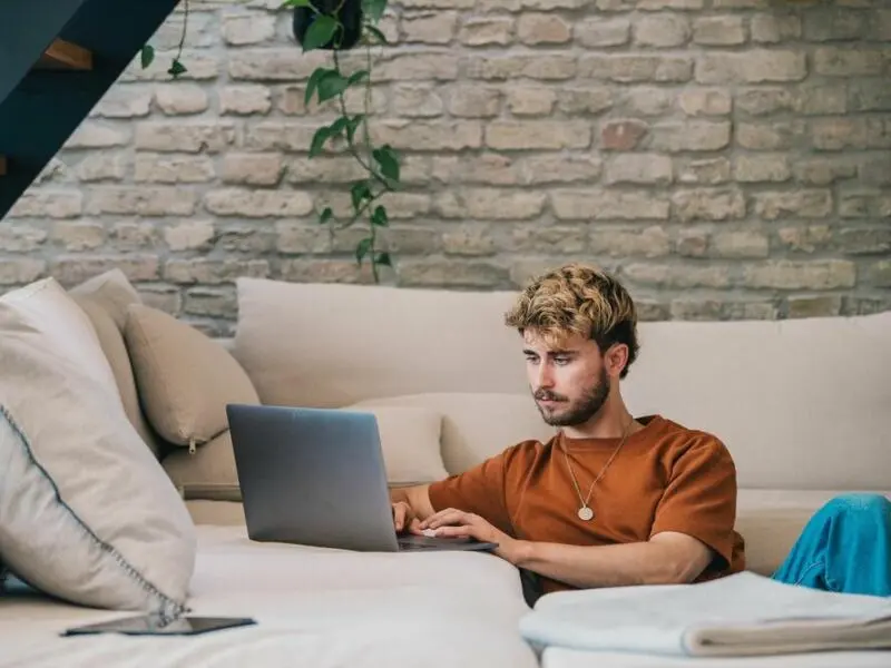 Ein junger Mann arbeitet am Laptop