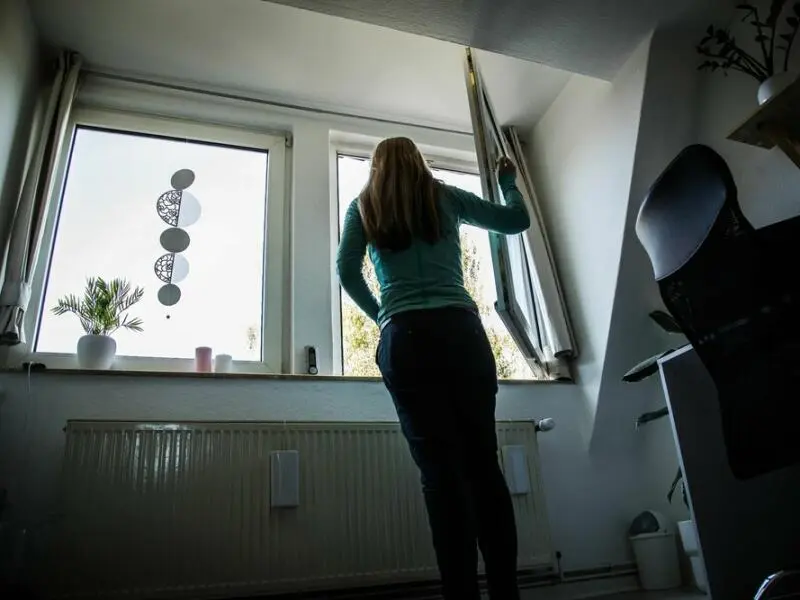 Eine Person öffnet ein Fenster