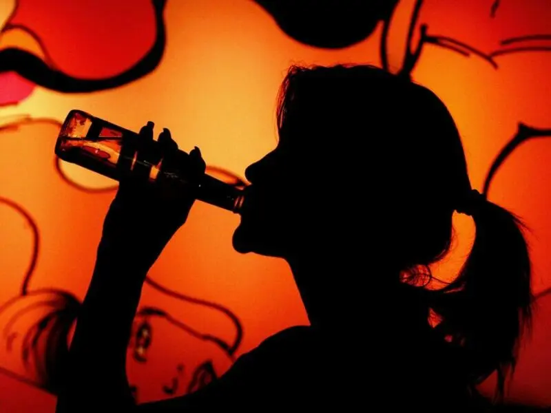 Frau trinkt in einer Bar Alcopop