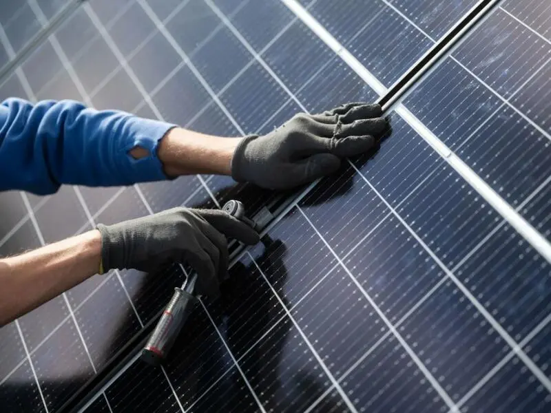Eine Person installiert eine Photovoltaikanlage