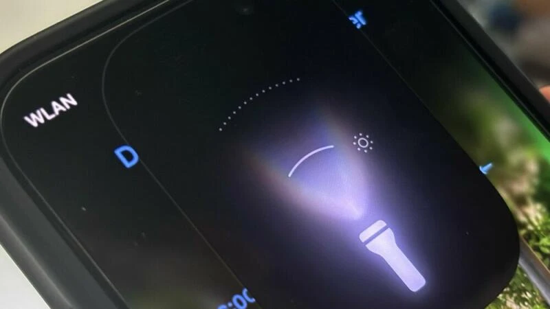 Lichtstrahl der Taschenlampe eines iPhone unter iOS 18