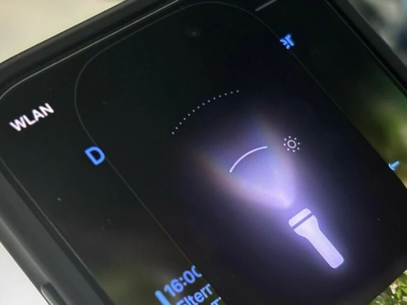 Lichtstrahl der Taschenlampe eines iPhone unter iOS 18