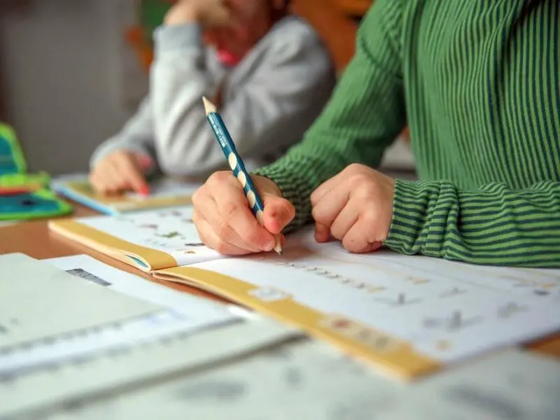 Ein Kind schreibt in einem Übungsheft