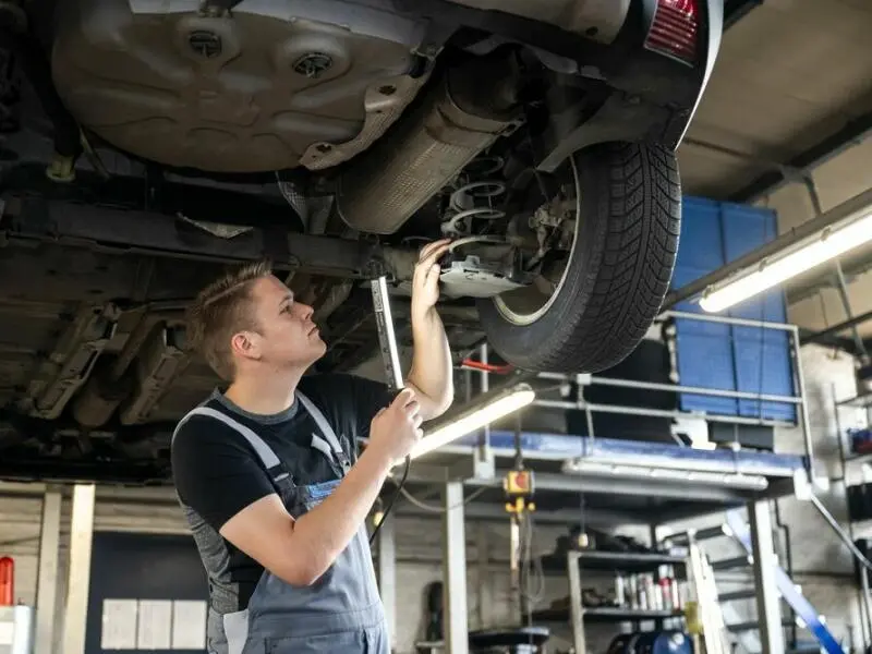 Ein Mechatroniker arbeitet in einer Autowerkstatt