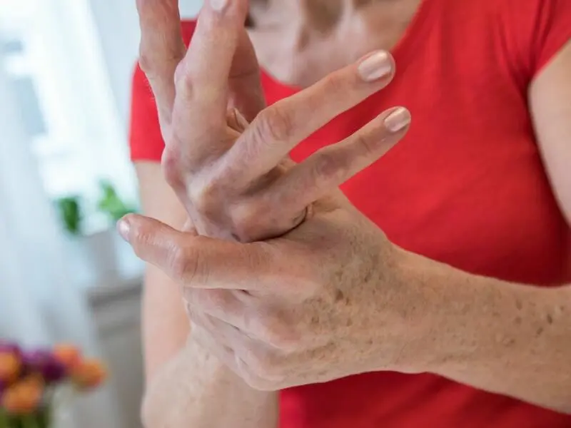 Eien Frau reibt sich ihre schmerzende Hand