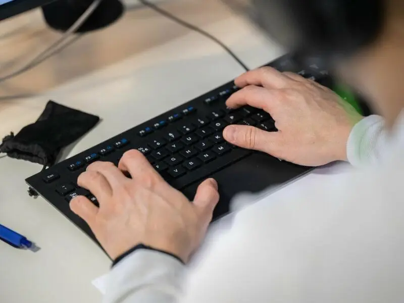 Mann arbeitet an einer Computer-Tastatur