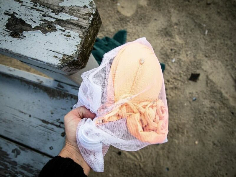 Bikini in einem Wäschenetz am Strand