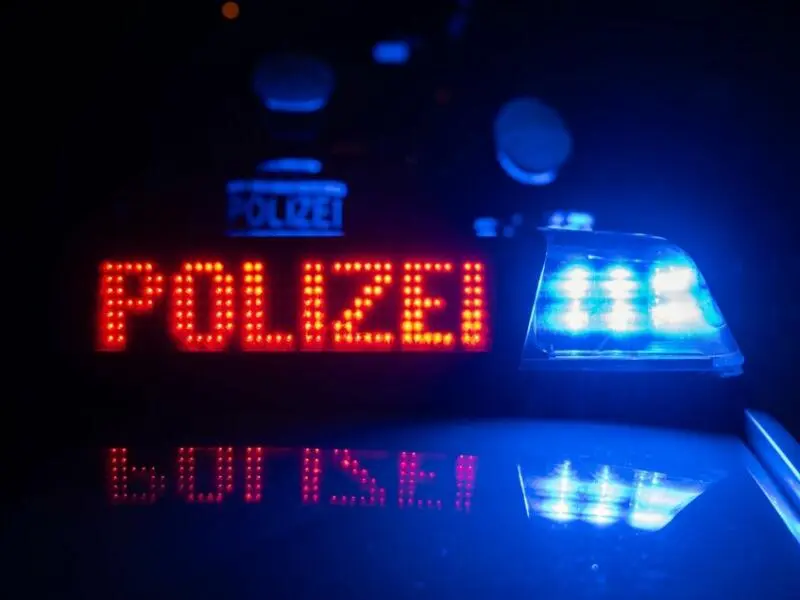 Polizisten vor einem Polizeiauto