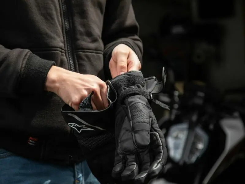 Mann zieht Motorradhandschuhe an