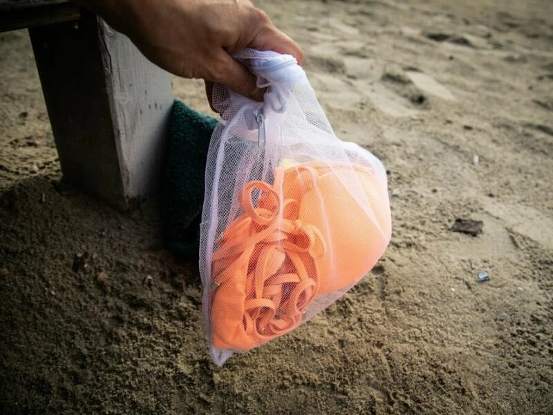 Bikini in einem Wäschenetz am Strand