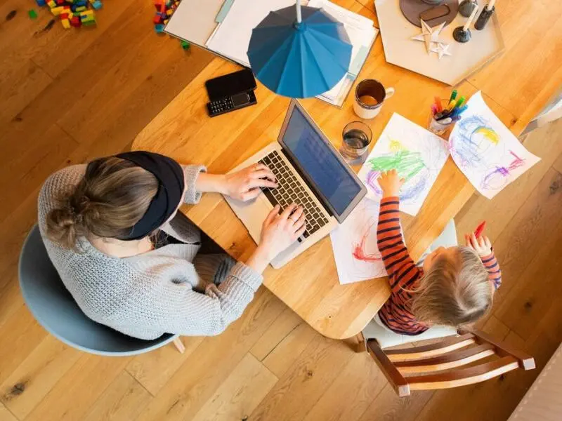 Eine Frau arbeitet im Homeoffice mit Kind