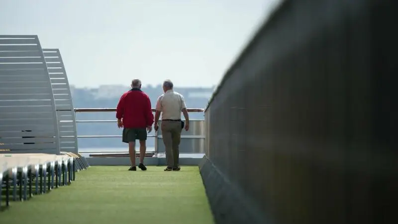 Ältere Passagiere auf dem Oberdeck eines Kreuzfahrtschiffs