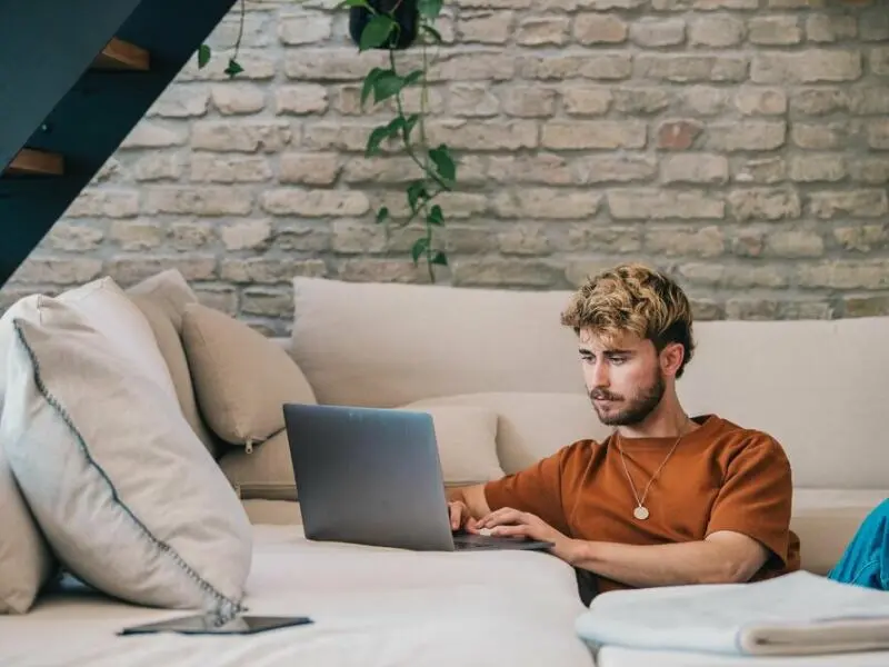 Ein junger Mann arbeitet am Laptop